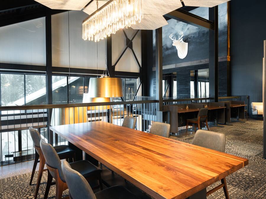 Un espace de salle à manger moderne avec une table en bois, des chaises et un lustre.