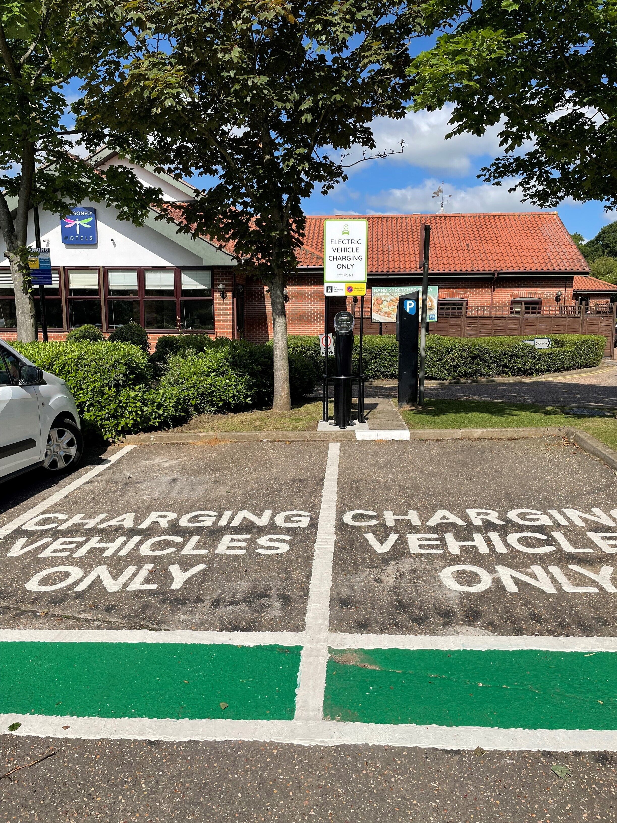 A parking area with 'Electric Vehicle Charging Only' signs and a 'Hand Stretch' sign.