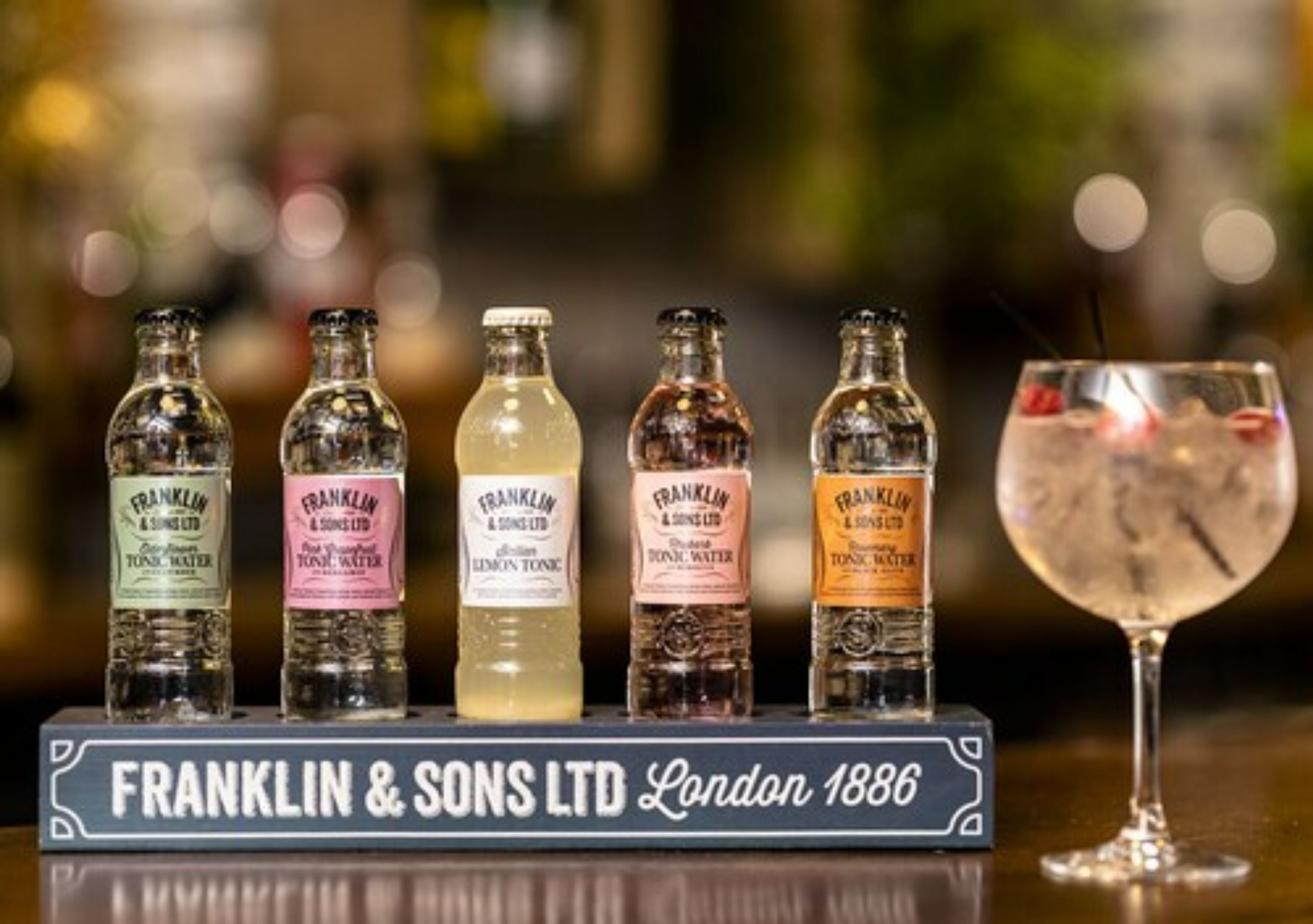 A display of vintage bottles labeled 'Franklin & Sons Ltd' and a glass of cocktail.
