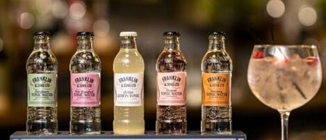 A display of vintage bottles labeled 'Franklin & Sons Ltd' and a glass of cocktail.