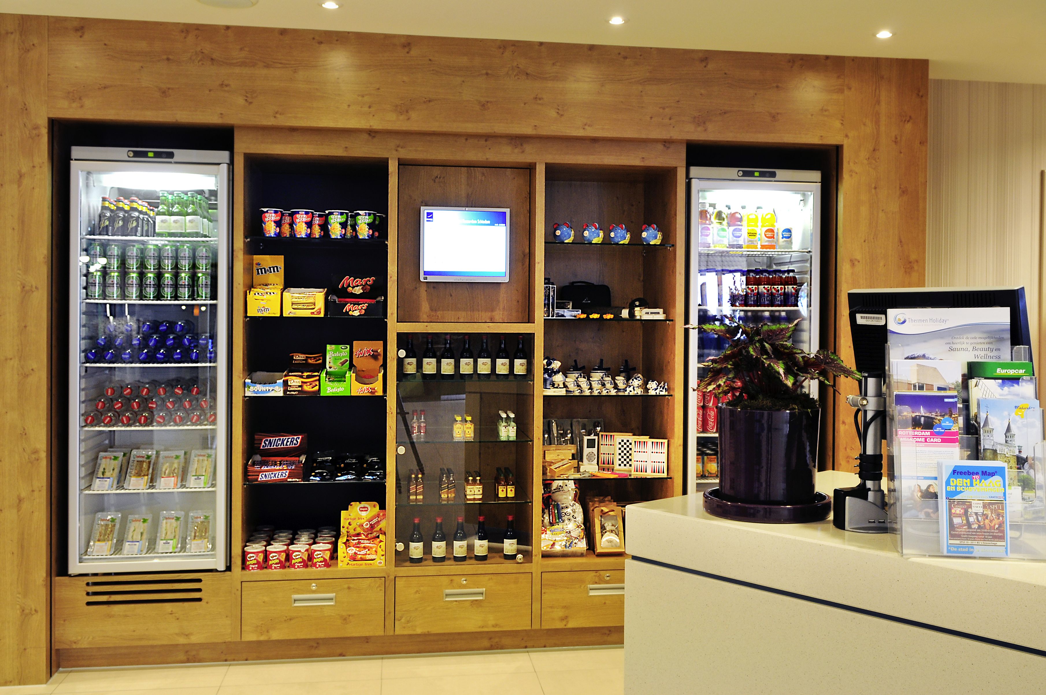 A vending machine area with various snacks, drinks, and a digital screen displaying information.