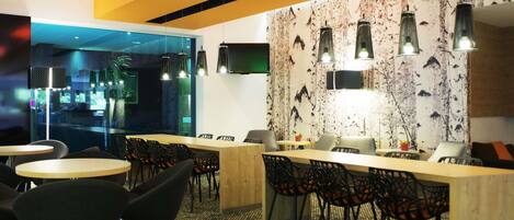 Een modern interieur met een bar, zitplaatsen en een patroonwand.