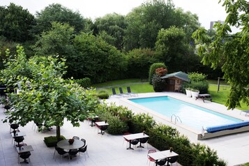 Una piscina al aire libre de temporada, tumbonas