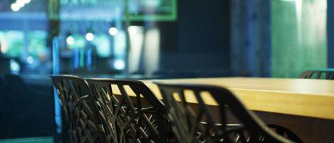 A modern dining area with a wooden table and black chairs.