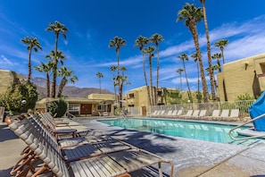 Alberca al aire libre, sombrillas en la alberca y camastros