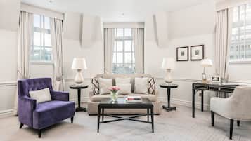 A modern living room with a sofa, armchairs, a coffee table, and a desk.