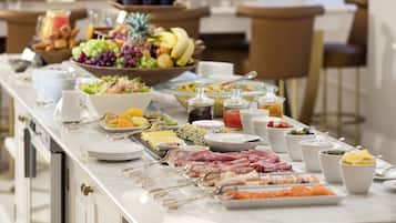A buffet with various food items and utensils.
