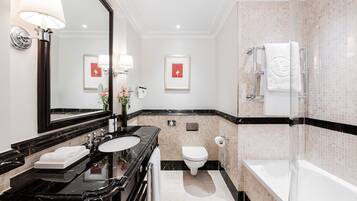 Ein modernes Badezimmer mit einem schwarzen Marmorwaschbecken, einer weißen Toilette und einer Duschkabine aus Glas.