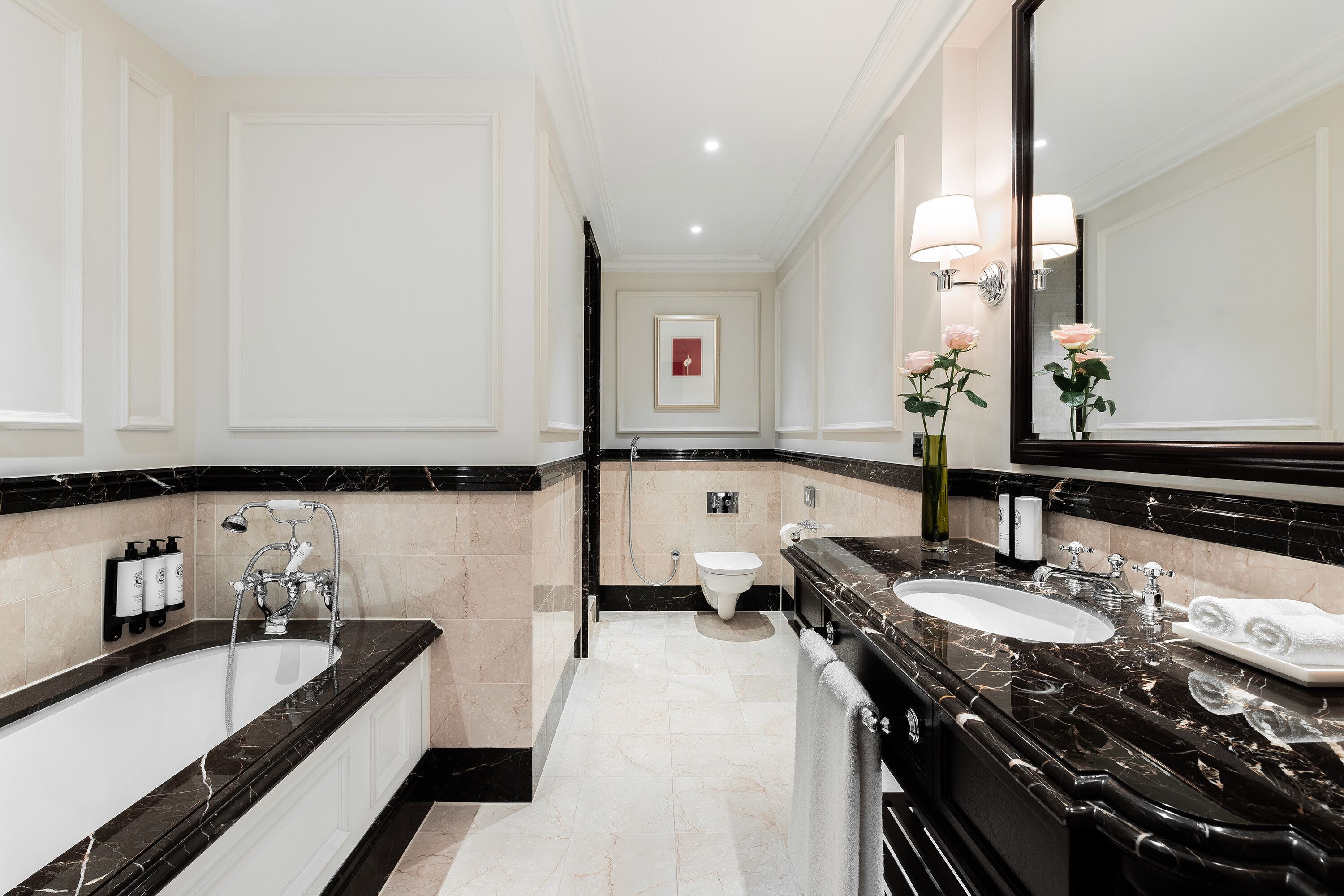 Un baño moderno con lavamanos doble, bañera y espejo grande.