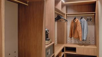 A wooden closet with hanging space and a built-in safe.