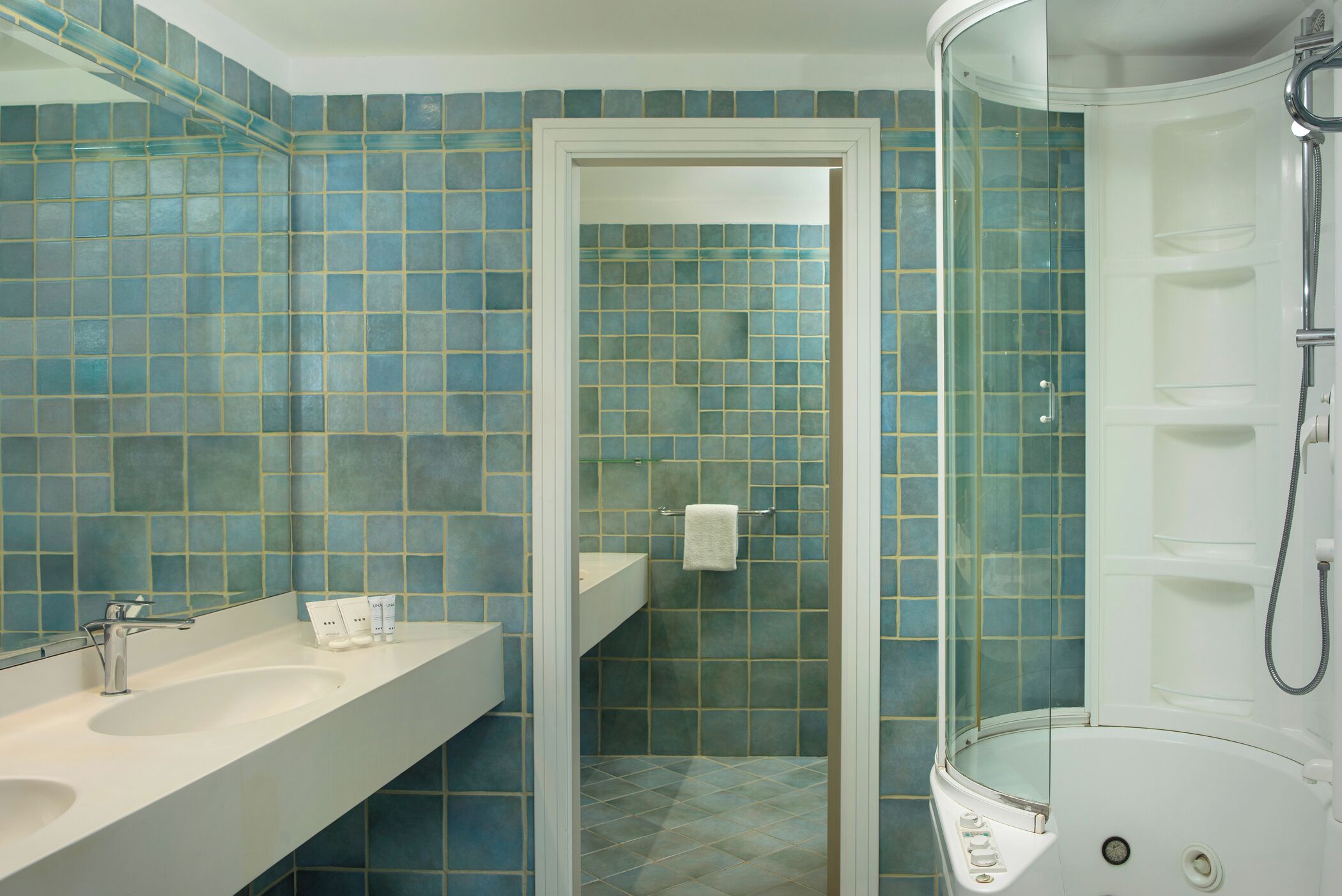 Un baño con ducha, lavamanos y espejo.