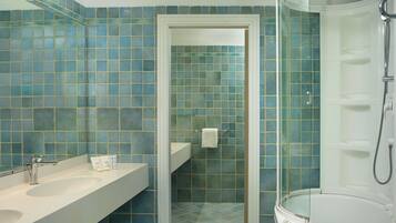 Un baño con ducha, lavamanos y espejo.
