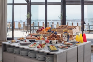 Un buffet proposant une variété de plats et offrant une vue sur la ville grâce à de grandes fenêtres.