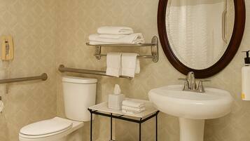 A bathroom with a toilet, a sink, a mirror, and a towel rack.
