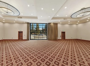 Conference room with high ceilings and large windows offering views of the surrounding landscape.