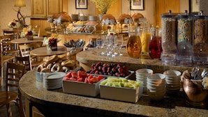 Un buffet proposant une variété de plats, de verrerie et d’ustensiles.