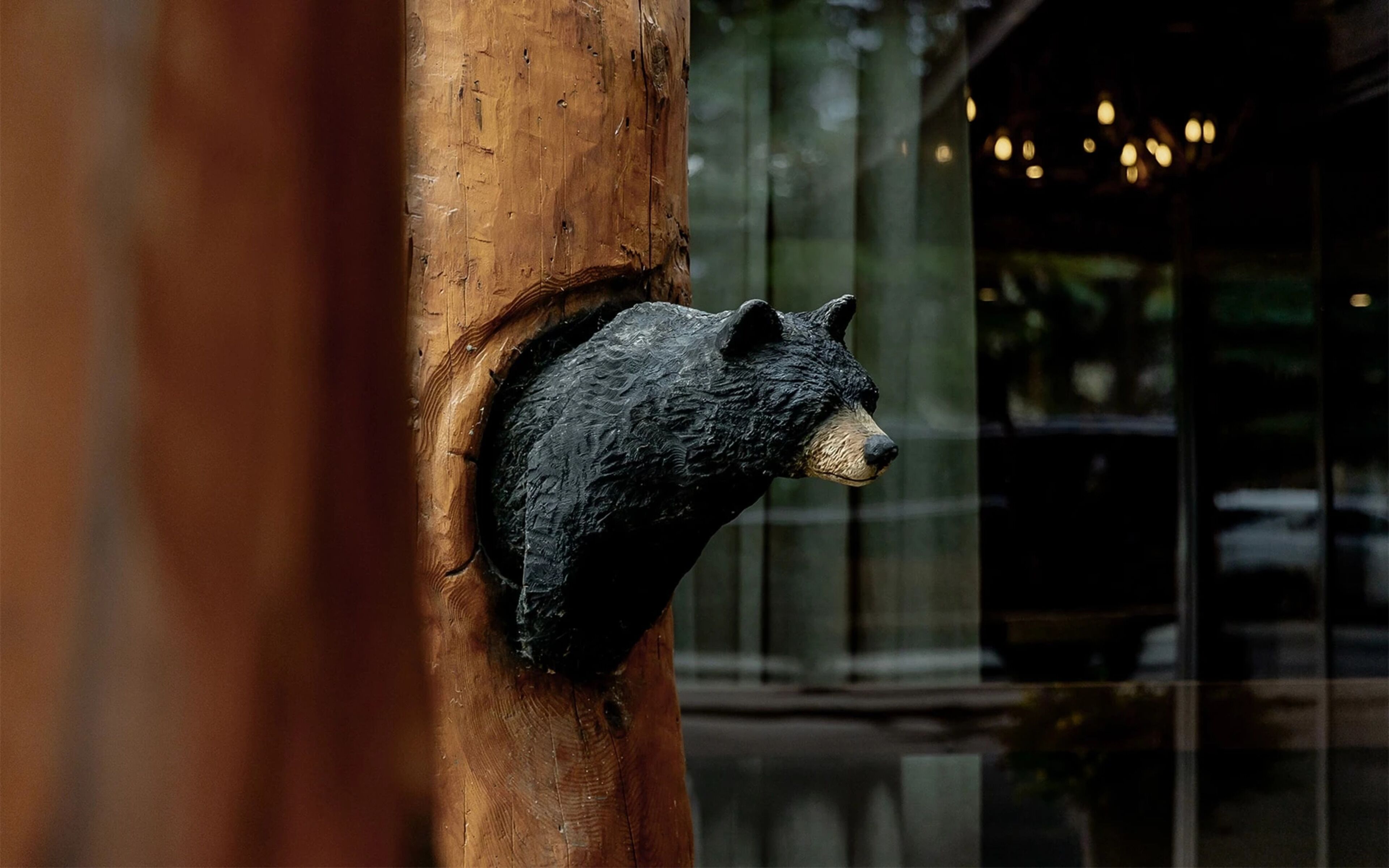 Un poste de madera con una escultura de oso adherida.
