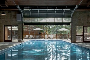 Una piscina cubierta, una piscina al aire libre, tumbonas