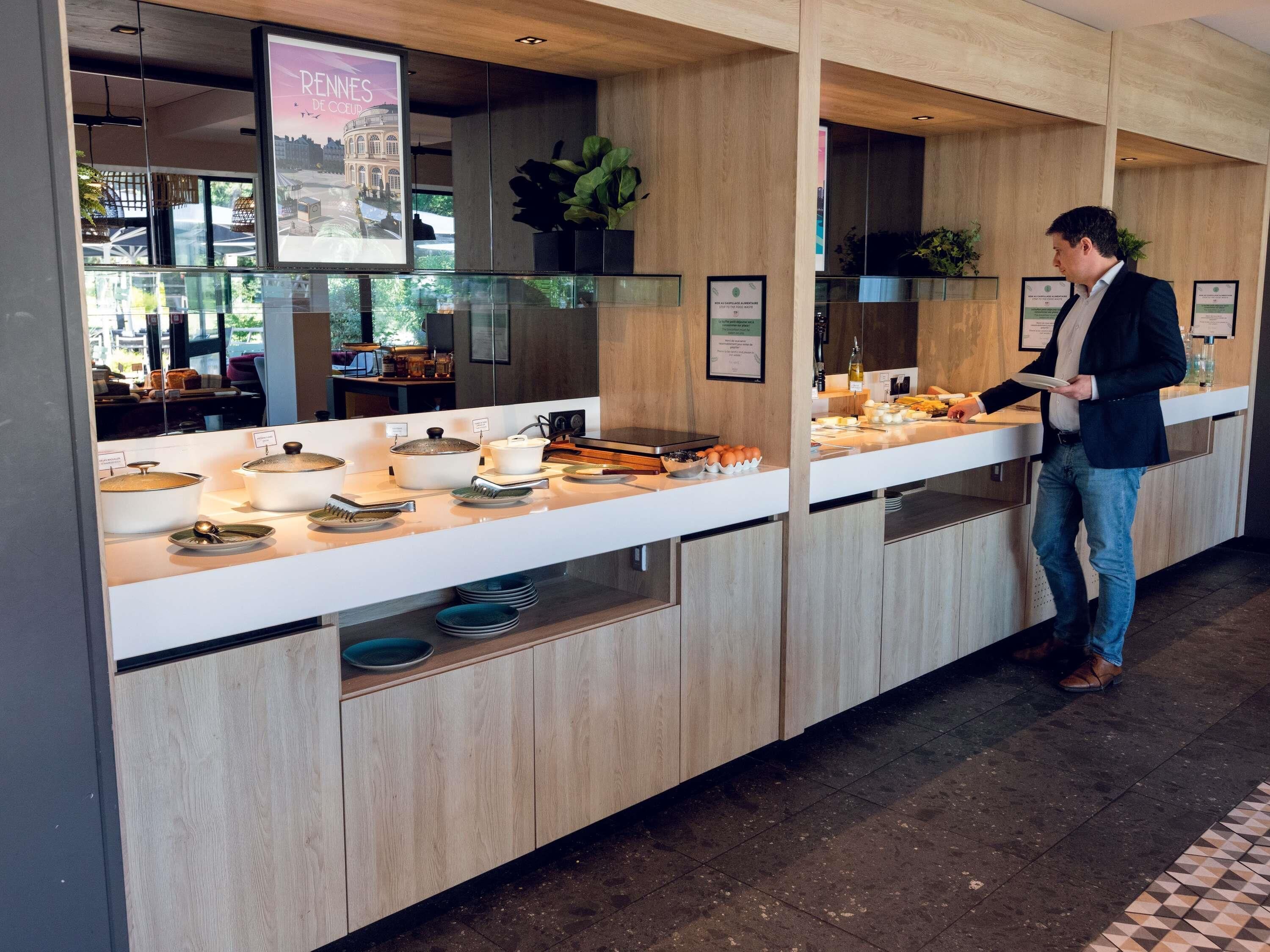 Een buffetgedeelte met diverse gerechten en een persoon die serveert.