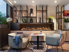 Una sala de estar moderna con chimenea, asientos y estantes decorativos.