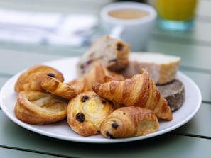 A plate of croissants and a cup of coffee on a table.