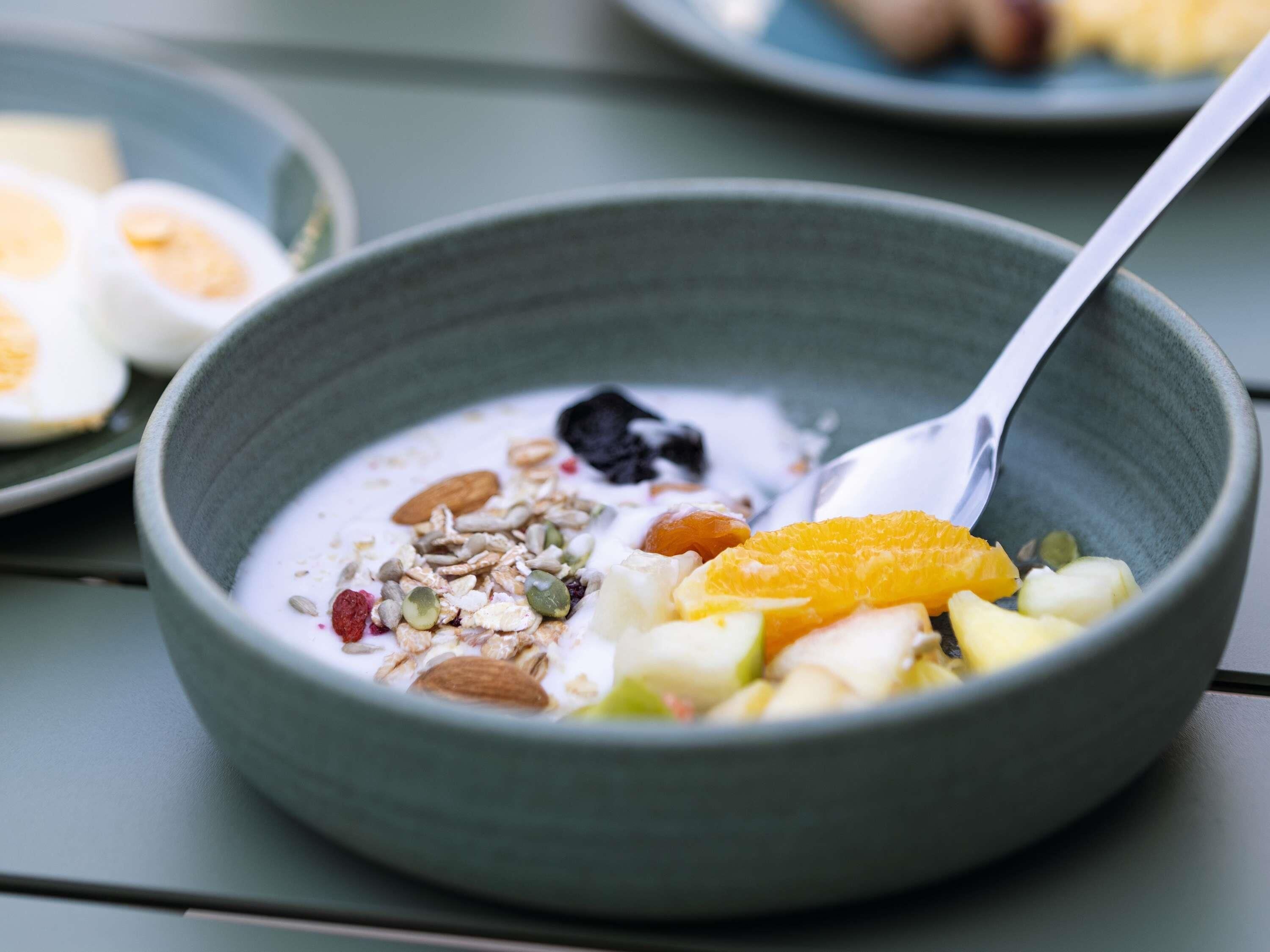 A bowl of cereal with fruits and nuts.