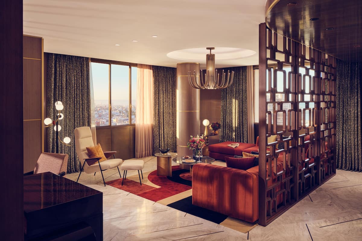 A modern living room with a large window, a grand piano, a red sofa, and a decorative partition.