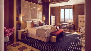 Une chambre d’hôtel moderne avec un grand lit, des tables de chevet, un bureau et une vue sur la ville.