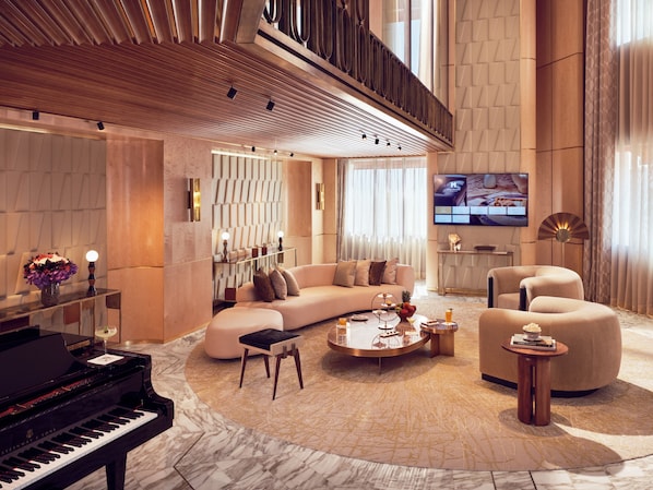 Un amplio salón con un piano de cola, un sofá modular y una mesa de centro.