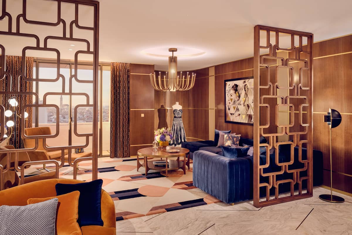 A modern living room with a city view, a chandelier, and a blue sofa.