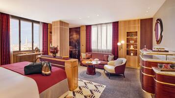 Una habitación de hotel con cama, sofá, escritorio y zona de comedor.