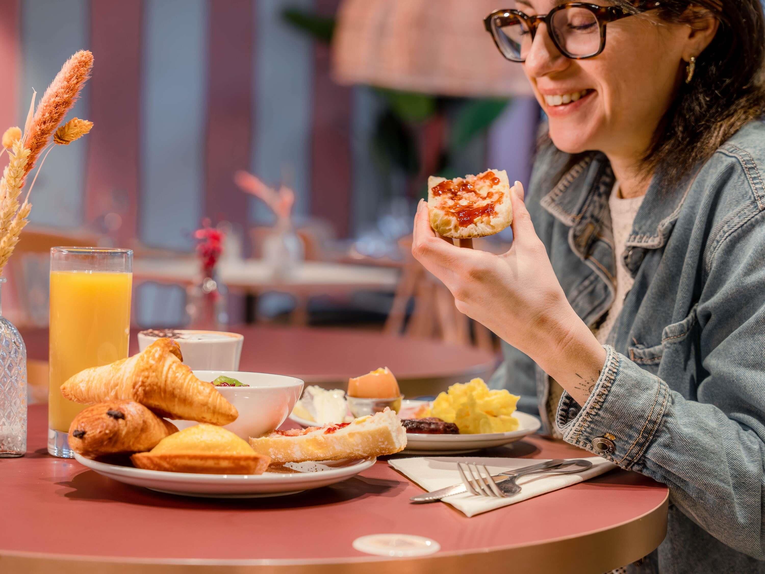 Ein Frühstückstisch mit Croissants, einem Glas Orangensaft und einem Teller Rührei.