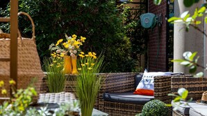 Wicker furniture, potted plants, and a brick wall. - Hotel ibis Lille Centre Gares (Lille)