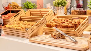 Wooden bread baskets with various baked goods, a cutting board with a loaf of bread, and a sign indicating 'PAIN'. - Hotel ibis Lille Centre Gares (Lille)