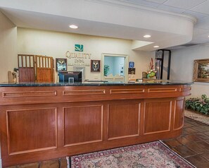 A hotel reception desk with a wooden counter, a Dell computer, and a sign indicating the hotel is by Choice Hotels. - Quality Inn Ennis (Ennis)