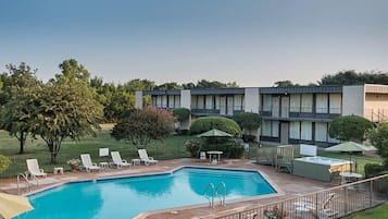 A swimming pool with lounge chairs and a fenced patio area.