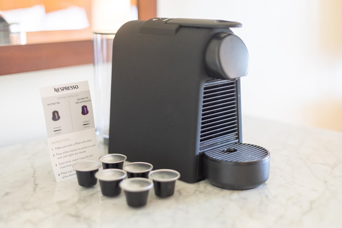 A coffee machine with capsules and instructions on a marble countertop.