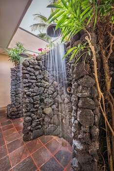 A resort with a large building, a pond, and tropical landscaping. at Grand Hyatt Kauai Resort and Spa