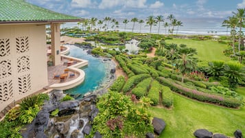Un resort con piscina, palmeras y vista al océano.