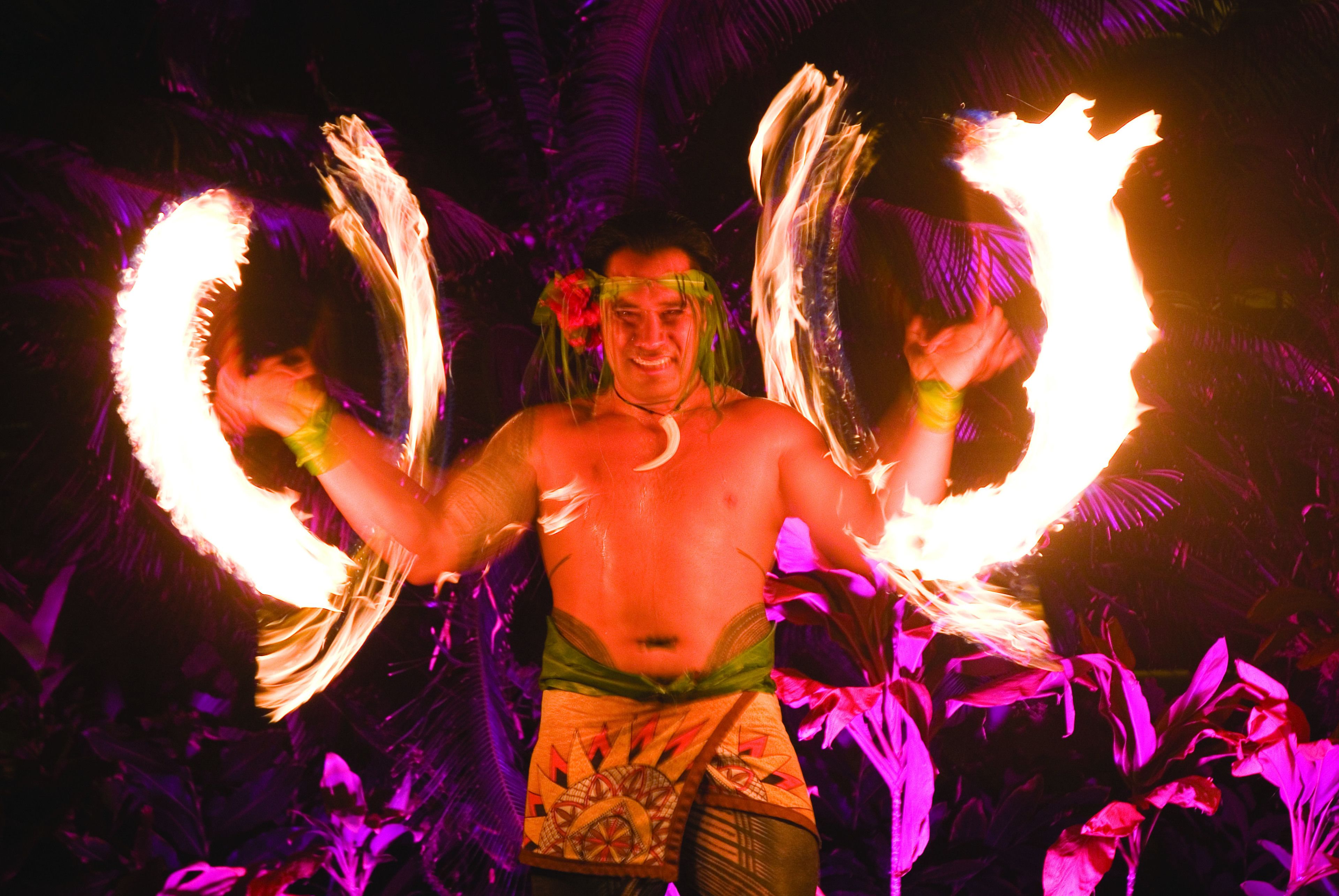 A person performing fire tricks with flaming torches.