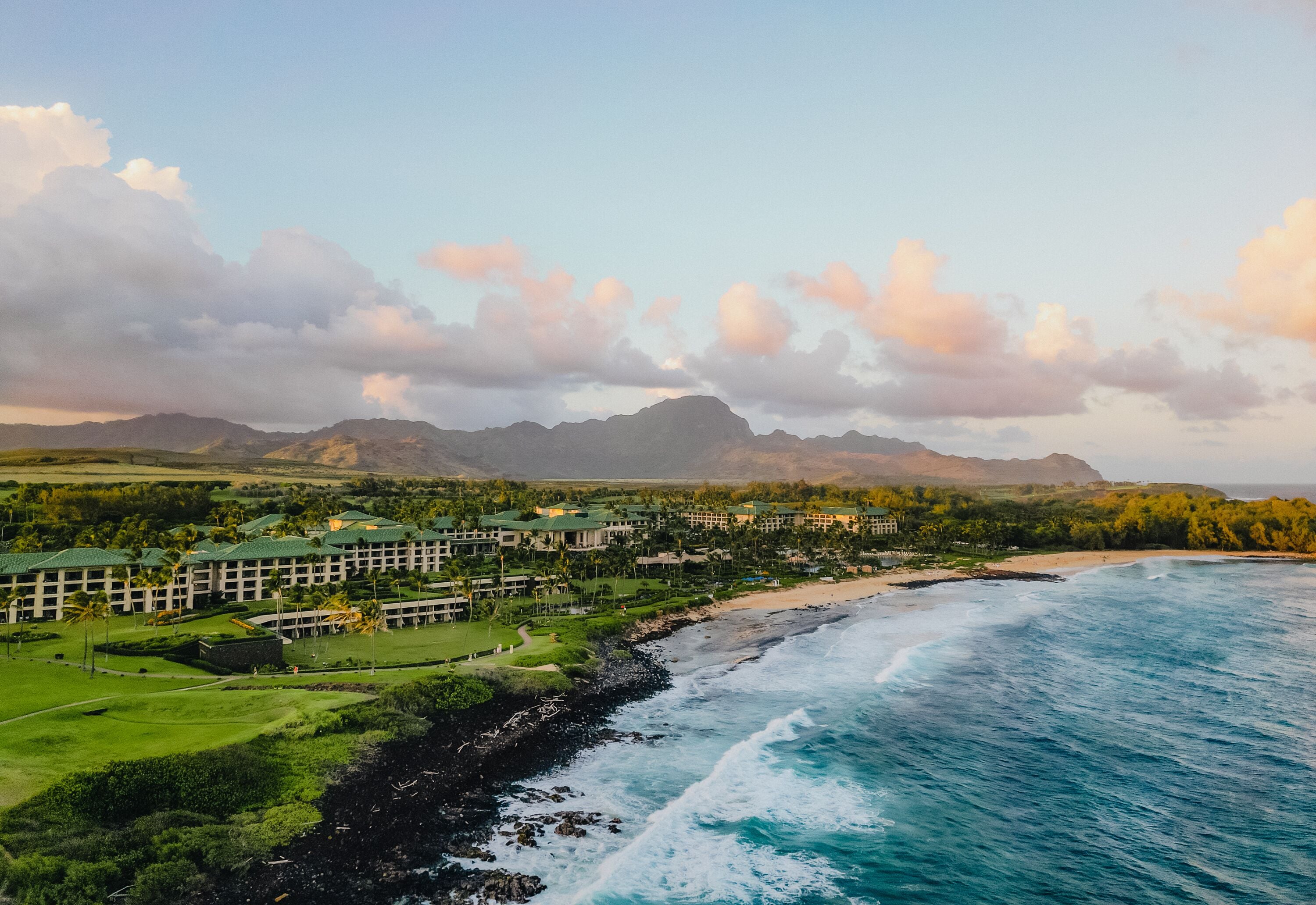 A resort with multiple buildings, a beach, and ocean views.