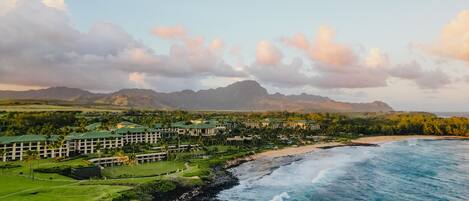 A resort with multiple buildings, a beach, and ocean views.