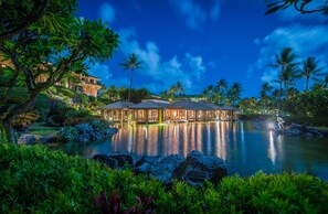 A resort with a large building, a pool, and palm trees. - Grand Hyatt Kauai Resort and Spa (Koloa)