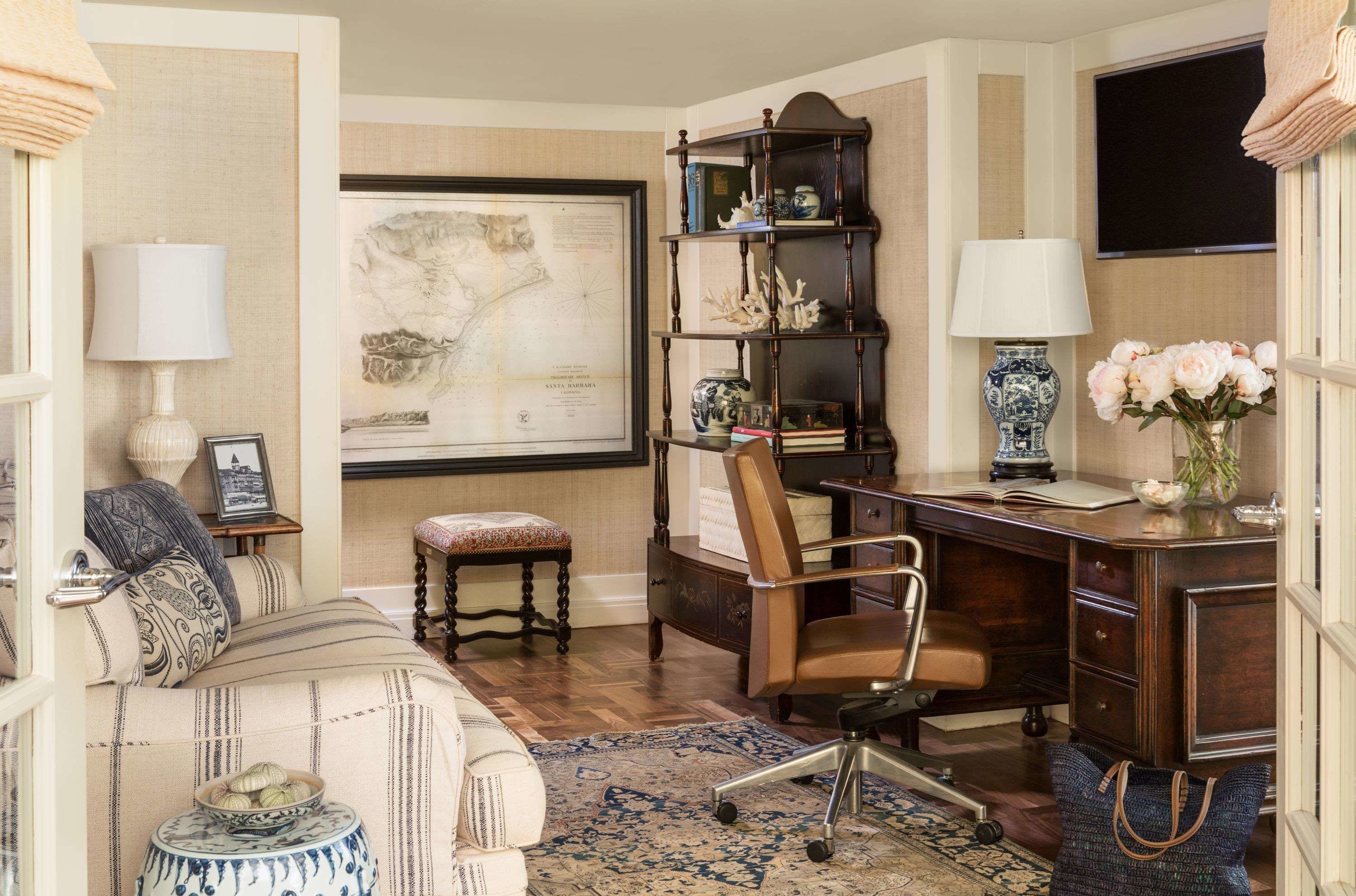 A well-furnished room with a desk, chair, bookshelf, and a large map on the wall.