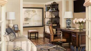 A well-furnished room with a desk, chair, bookshelf, and a large map on the wall.