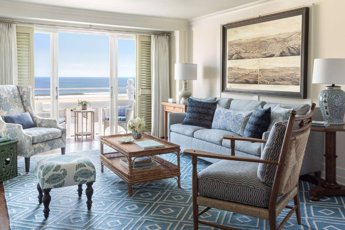 A spacious living room with a view of the beach, a large framed artwork, and a comfortable seating area.