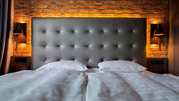 A bed with a tufted headboard, two bedside lamps, and a brick-patterned wall.