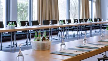 Ein Konferenzraum mit langem Tisch, Stühlen und einem Getränkekühler.