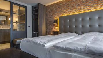 Un dormitorio moderno con pared de ladrillo, cabecera capitonada y un espejo grande.