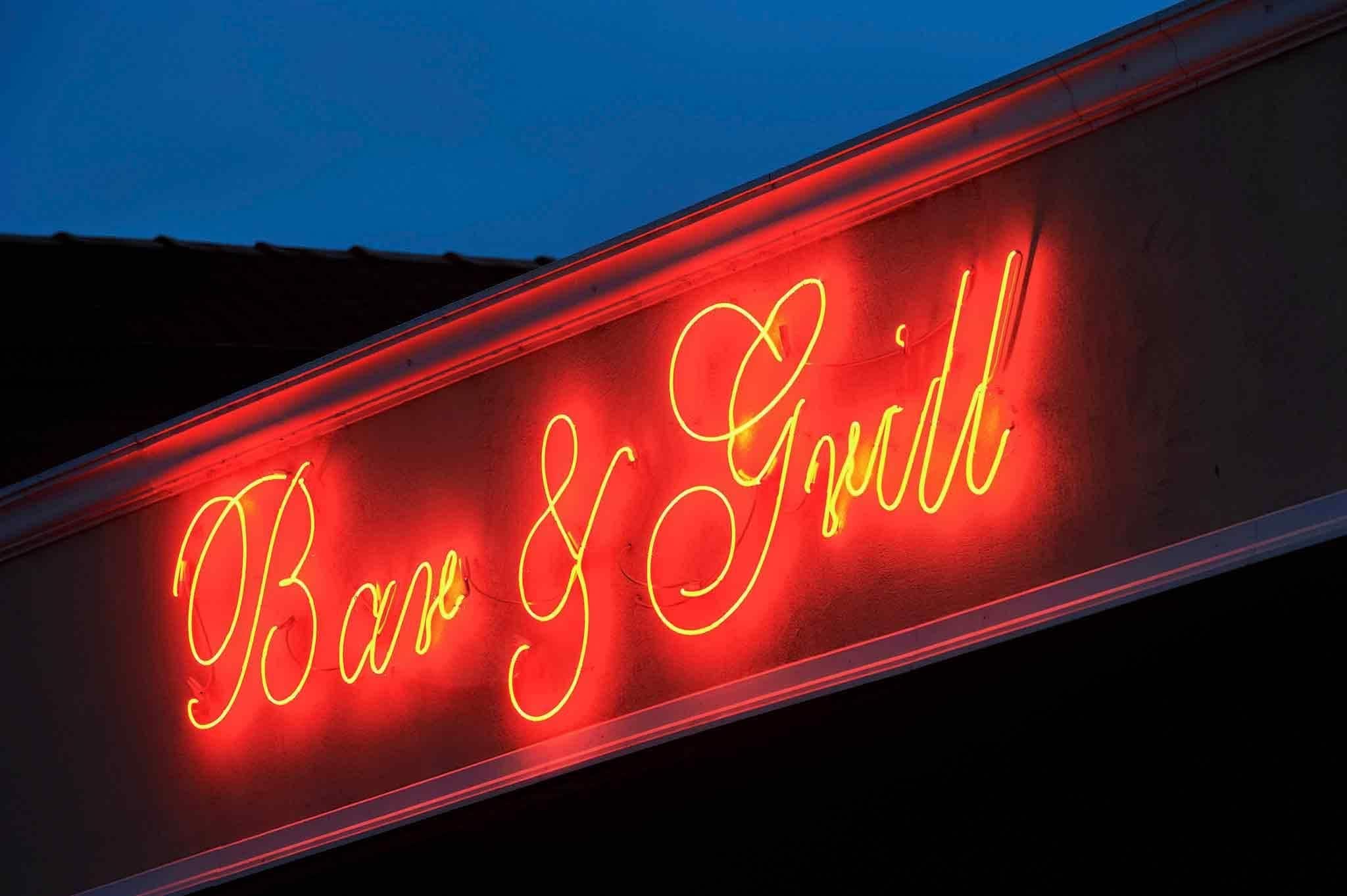 A neon sign with the words "Bar & Grill" in cursive lettering.
